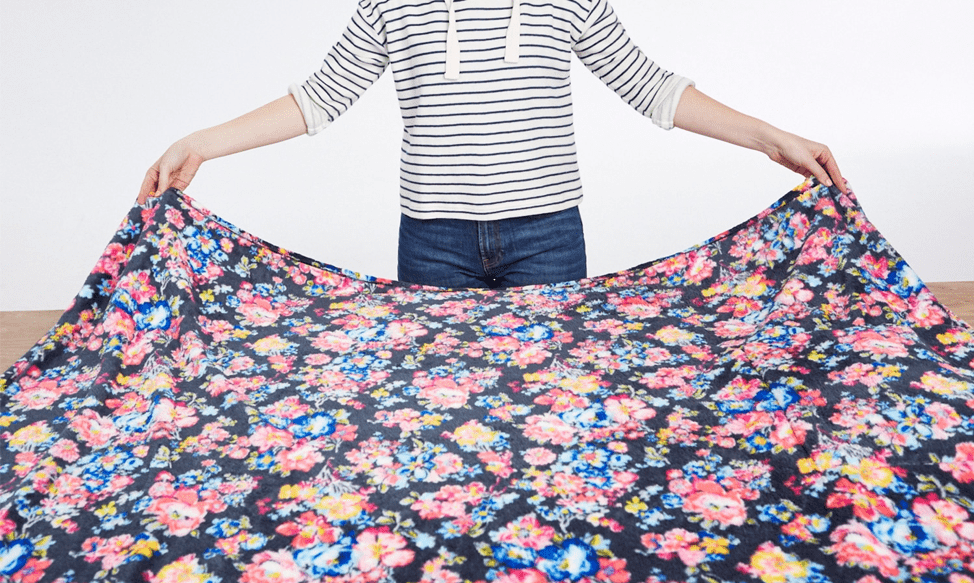 Person laying a fleece blanket out on a clean surface